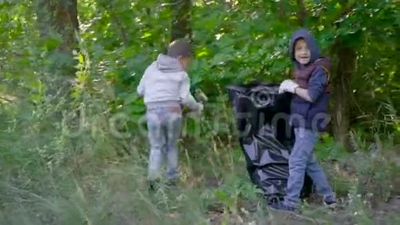 孩子们正在把森林里的垃圾放进黑色塑料袋里共同清理领地视频的预览图