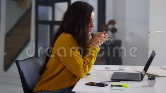 专注商业女性在办公室工作笔记本电脑喝茶的美女视频的预览图