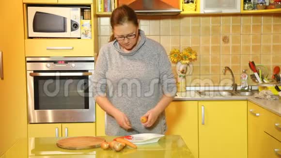 一个戴眼镜的女人在厨房里剥胡萝卜视频的预览图