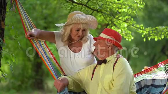 在夏日花园里休息的一对迷人的老年夫妇视频的预览图