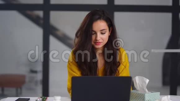 生病的女商人在办公室得流感病妇在室内笔记本电脑附近打喷嚏视频的预览图