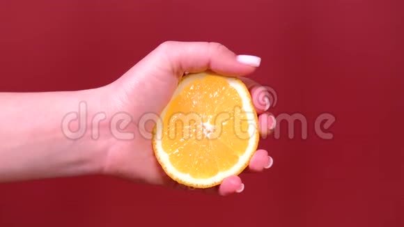 女性用手捏着红色的橙色视频的预览图