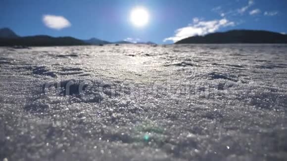 阳光明媚的一天年轻人在雪地上慢跑面目全非的家伙跳在雪地草地上举手太阳光线视频的预览图