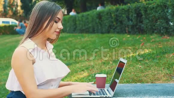 迷人的金发女孩学生在市中心使用笔记本电脑受到自然美的启发快关门复制空间4K视频的预览图