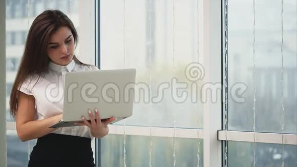 商务女性正在使用一台灰色笔记本电脑隔离在光线全景模糊的背景上复制空间快关门4K视频的预览图