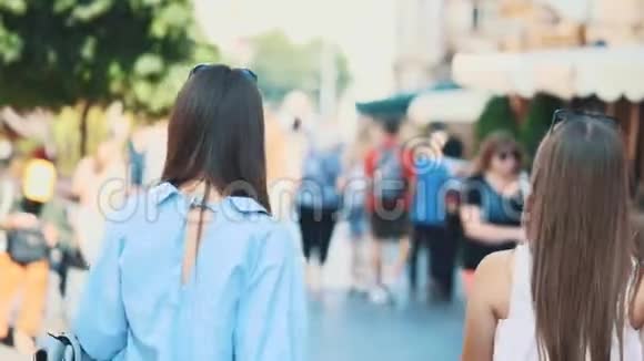 两个漂亮的女孩在购物后漫步街头玩得很开心后景快关门副本视频的预览图