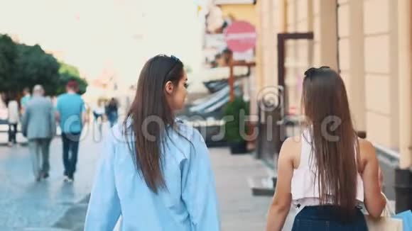 两个漂亮的女孩在购物后漫步街头玩得很开心后景复制空间4K视频的预览图