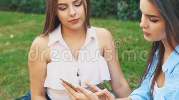 两个有魅力的年轻女人正在一个夏天的公园里聊天快关门作物复制空间4K视频的预览图