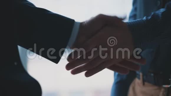 两个人握手友好的男人正在握手商业伙伴都在握手背景模糊关门视频的预览图