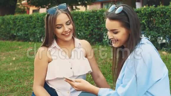 两个有魅力的年轻女人正在一个夏天的公园里聊天快关门复制空间4K视频的预览图