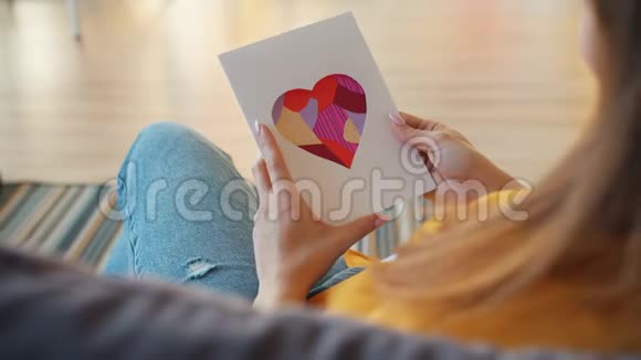 拿着情人节卡片说我爱你坐在家里的沙发上视频的预览图