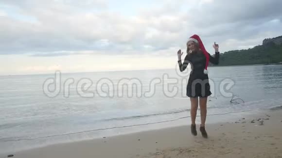 戴着圣诞帽的滑稽女人在海边跳舞视频的预览图