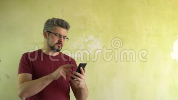 那个人把手指按在智能手机屏幕上对着光墙视频的预览图