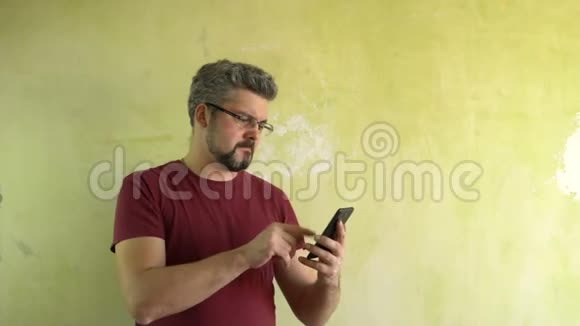 那个人把手指按在智能手机屏幕上对着光墙视频的预览图