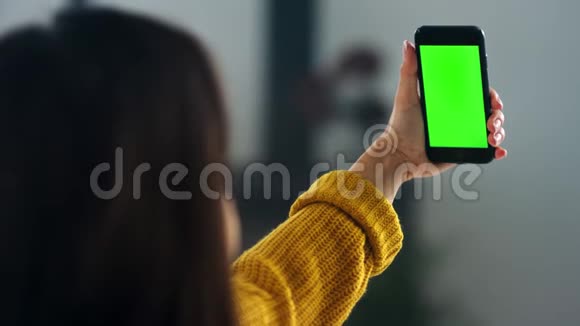 女孩在智能手机上用绿色屏幕打视频电话漂亮的女人在挥手视频的预览图