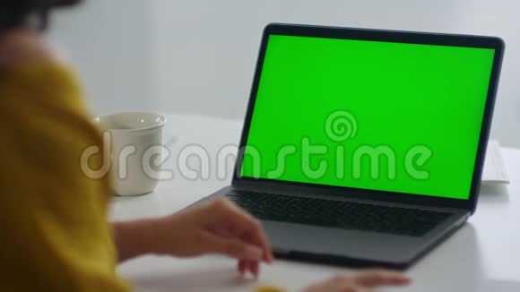 看不见的女人看着绿色屏幕笔记本电脑女孩用手势解释视频的预览图
