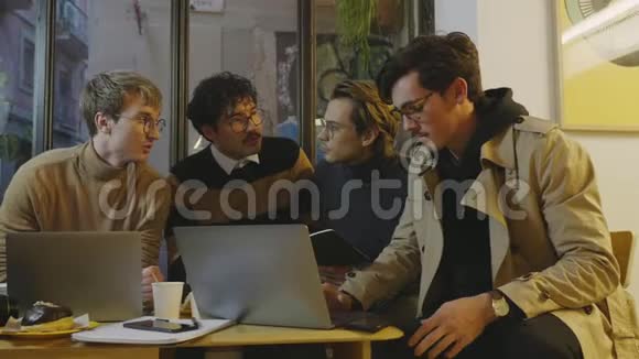 自由职业者在谈论咖啡店的项目使用笔记本电脑的专业人员视频的预览图