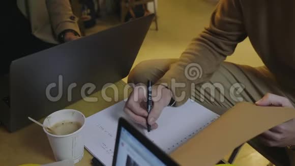 商人在咖啡馆用笔记本做笔记男性自由职业者视频的预览图
