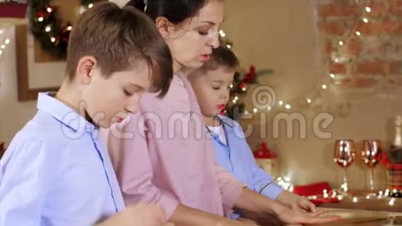 和母亲在一起的孩子们正在制作一个面团在圣诞节做饼干视频的预览图