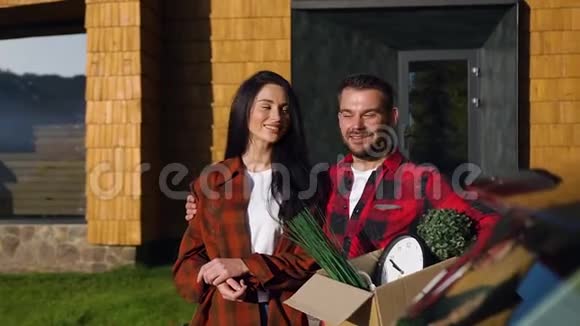 迷人的微笑男人和女人站在漂亮的房子附近对着镜头摆姿势视频的预览图