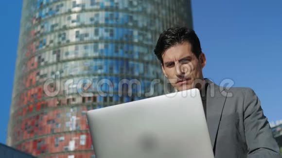 商人在户外笔记本电脑上浏览互联网专业使用计算机视频的预览图