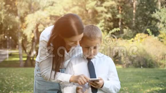 妈妈帮助儿子理解手机上的应用程序视频的预览图