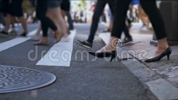 时尚女性脚的近景女商人在拥挤的市中心过马路慢动作视频的预览图