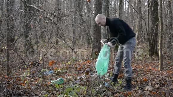 志愿者用塑料袋收集一个人在森林里留下的塑料瓶视频的预览图