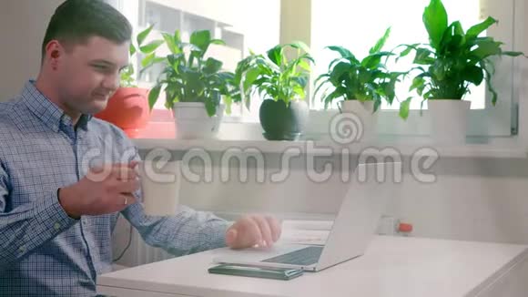 年轻人一边喝咖啡一边工作笔记本电脑视频的预览图