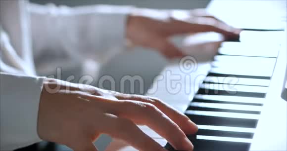 女或女学生或职业钢琴家在一架漂亮的白色钢琴上演奏古典音乐钢琴家的手视频的预览图