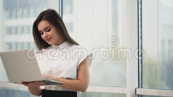 商务女性正在使用一台灰色笔记本电脑隔离在光线全景模糊的背景上复制空间快关门4K视频的预览图