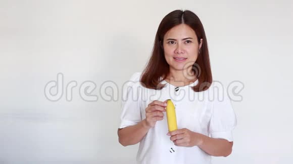 年轻的亚洲女人拿着生香蕉视频的预览图