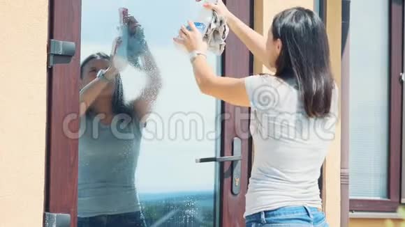 女人在外面用灰色抹布擦玻璃复制空间4公里视频的预览图