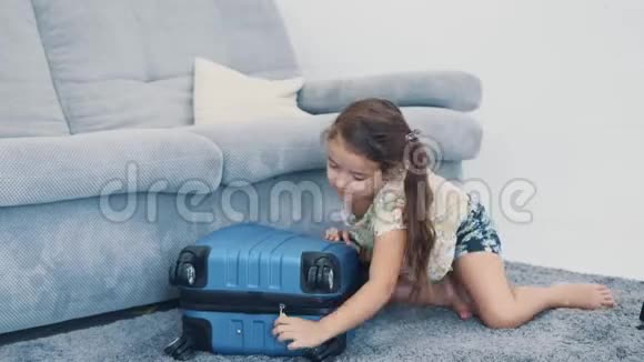 棕色头发的小女孩把玩具从旅行箱里拿开闭合4公里视频的预览图
