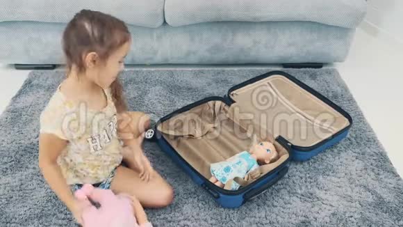 孩子把她的玩具放在旅行箱里快关门4K视频的预览图