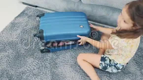 孩子把她的玩具从旅行箱里放下来快关门4K视频的预览图
