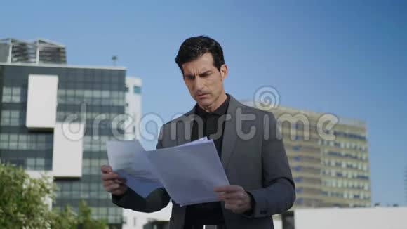 商人在街上阅读文件男性经理看商业文件视频的预览图