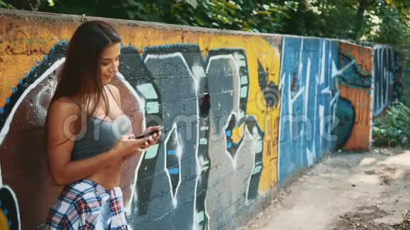 快关门美丽的健身女孩在锻炼后使用电话侧视复制空间4K视频的预览图