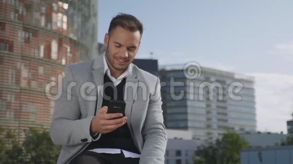 商人在街上用智能手机打字商务经理打电话视频的预览图
