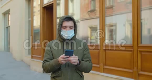 戴防护面罩的人使用电话COVID19冠状病毒感染一个白种人的医疗画像视频的预览图