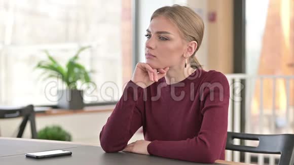 沉思的年轻女子在办公室里思考视频的预览图