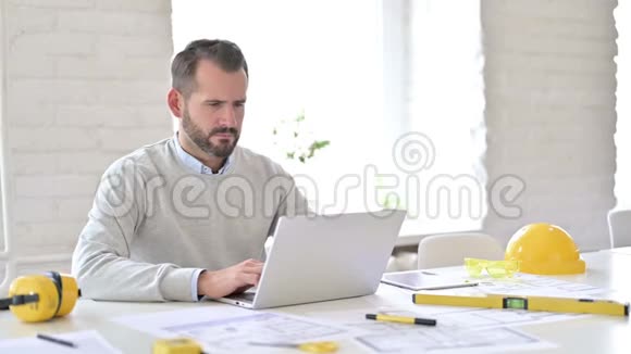 带笔记本电脑的年轻建筑师在办公室头痛视频的预览图
