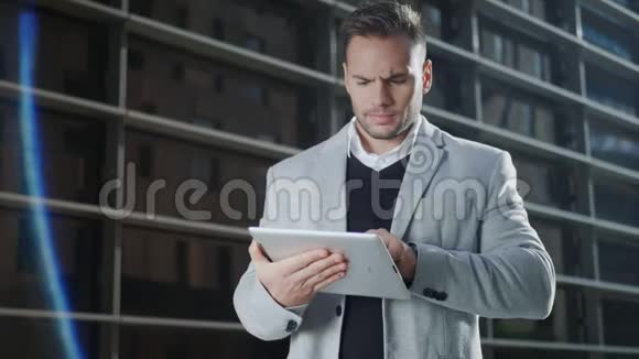 商人在城市里做数字平板电脑执行使用触摸板视频的预览图