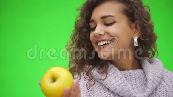 微笑着健康的年轻非洲女人正在闻一个绿色的苹果快关门复制空间视频的预览图
