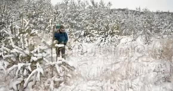 有胡子的成熟男人在雪地森林里徒步旅行视频的预览图