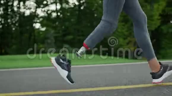 在公园里做假肢运动的女跑步者女孩的腿在户外跑步视频的预览图