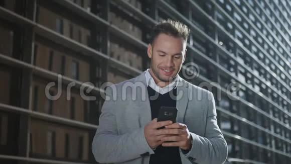 商人在街上使用智能手机工人通过电话浏览互联网视频的预览图