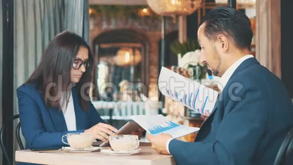 两个商人吃商务午餐餐馆或咖啡店里的男人和女人正在喝咖啡视频的预览图