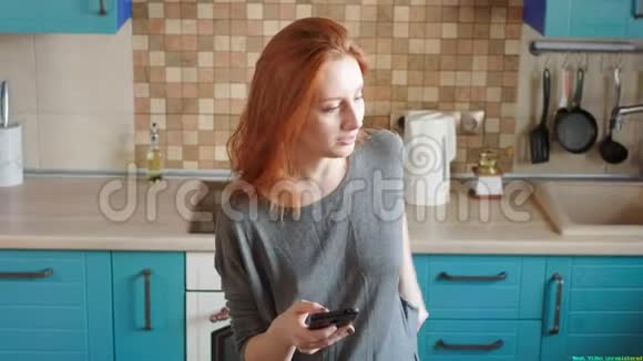 漂亮的红发女孩用智能手机和信用卡在网上商店购物购买空气视频的预览图