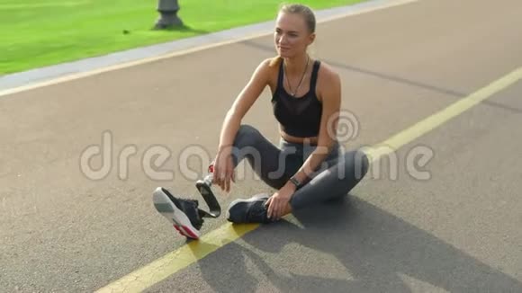 有假肢的女人坐在路上女孩在公园训练后放松视频的预览图